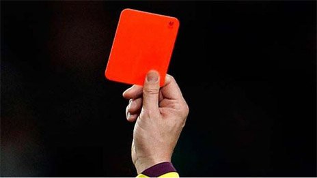 Árbitro mostrando una tarjeta roja como sanción.